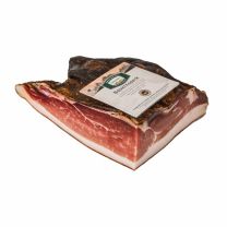 Exklusiver Südtiroler Bauernspeck – handgefertigt aus 100% Südtiroler Schweinefleisch, mit g.g.A.-Siegel ausgezeichnet und mindestens sechs Monate in frischer Bergluft gereift.