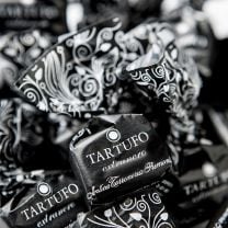 Tartufo extranero, eine Ode an die zart süße, dunkle Verführung, verpackt in schwarz-elegantem Papier, die anspruchsvolle Gaumen begeistert.